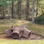 Rattanmöbel auf einer grünen Wiese im Wald