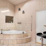Bad mit Whirlpool, Holzwand und Bar mit Stühlen