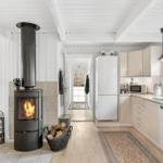 Küche mit Holzfußboden, Kaminofen und Küchenschränken