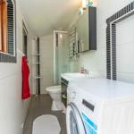 Badezimmer mit Dusche, Waschmaschine und Fenster