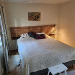 Schlafzimmer mit Bett, Holzkopfteil und Wandbild.