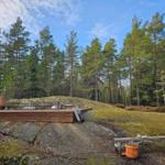 Holzterrasse auf Stein mit Sitzgelegenheiten im Wald