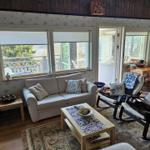 Wohnzimmer mit Sofa, zwei Sesseln und Blick auf Balkon