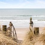 Holzsteg führt vom Dünenhügel direkt zum Strand und zum Meer.
