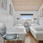 Two single beds, window with view, wooden ceiling and wall shelves.