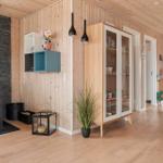Living area with wood paneling, fireplace, and glass-front cabinet.