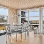 Dining room with white table and chairs, large windows, and view of terrace.
