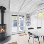 Raum mit Esstisch, Kamin und Glastüren zur Terrasse