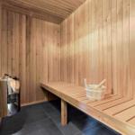 Sauna with wooden walls, bench, and bucket with ladle.