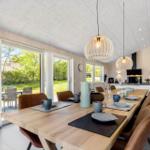 Dining area with wooden table, chairs, and view of the garden