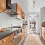 Kitchen with wooden cabinets, stone countertop, and view to terrace
