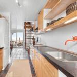 Kitchen with wooden cabinets, countertop, and view of terrace.