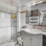Badezimmer mit Dusche, Waschbecken und Spiegelschrank.