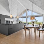 Moderne Küche mit Essbereich und großem Fensterblick.