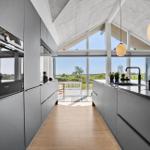 Moderne Küche mit Blick auf Terrasse und Landschaft.