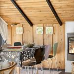 Essbereich mit Tisch, Stühlen und Kamin im Holzhaus.