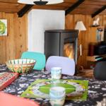Tisch mit Spiel und Bechern unter Holzdecke mit Kamin.