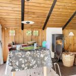 Esszimmer mit Holzwand, Kamin und Tisch mit Tischdecke.