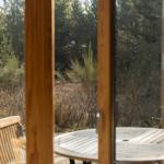 Terrasse mit Tisch und Stühlen, Blick in den Wald.
