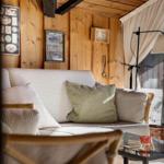 Wohnzimmer mit Holzwand, Sofa und Stehlampe.