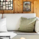 Sofa mit Kissen vor Holzwand mit Bildern