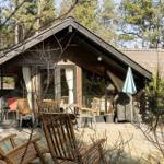 Haus mit Terrasse, Sitzgelegenheiten und Blick in den Wald.