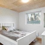 Bedroom with white bed, window, and mirror.