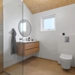 Bath with shower, sink, and toilet. Wooden ceiling and window.