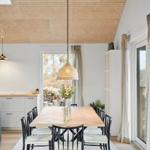 Dining area with wooden table, black chairs, and pendant lamp.