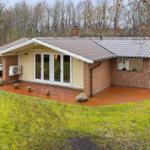 Haus mit Terrasse, Garten und Boot auf Anhänger