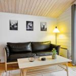 Wohnzimmer mit Sofa, Tisch und Fenster zur Außenterrasse.