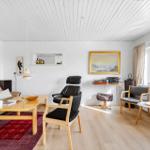 Living room with sofa, seating, and artworks on the walls.