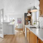 Kitchen with wooden cabinets and granite countertop. View into dining area with table and chairs.