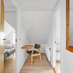 Hallway with table, chair, and view into bedroom and bathroom