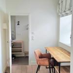 Essbereich mit Holztisch, Stuhl und Fenster. Durchgang zur Badewanne.