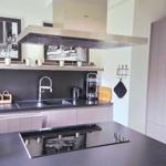 Moderne Küche mit Edelstahl-Abluft und integriertem Herd.