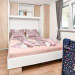 Schlafzimmer mit Bett, Schrank und Fenster