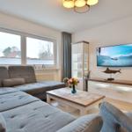 Wohnzimmer mit Sofa, Fernseher und Tisch