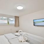 Schlafzimmer mit Bett, TV und Fenster mit Blick.