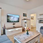 Wohnzimmer mit Fernseher, Couch und Tisch