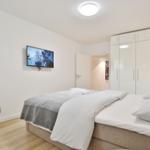 Schlafzimmer mit Bett, TV und Kleiderschrank.