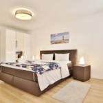 Schlafzimmer mit Bett, Nachttisch und Wandbild.