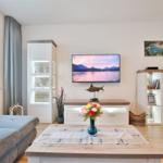 Wohnzimmer mit TV, Tisch, Sofa und Schränken.