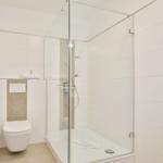 Badezimmer mit Dusche, Toilette und Waschbecken.