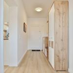 Flur mit Holzparkett, Kleiderschrank und Blick in die Küche.