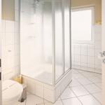 Badezimmer mit Dusche, Toilette und Fenster
