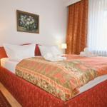 Schlafzimmer mit Bett, Vorhängen und Nachttisch