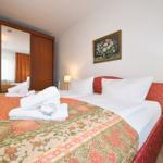 Schlafzimmer mit Bett, Nachttisch und Spiegeltüren.