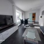 Wohn- und Essbereich mit TV, Glas-Tisch und Schlafplatz.