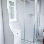 Badezimmer mit Dusche und weißem Schrank
